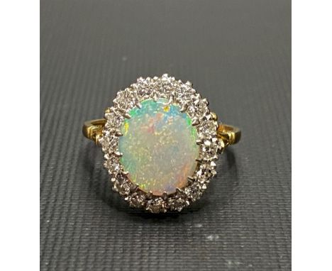 18ct white opal and diamond cluster ring, the opal displaying blue, green, pink and red colours, the diamonds of 0.04ct sprea