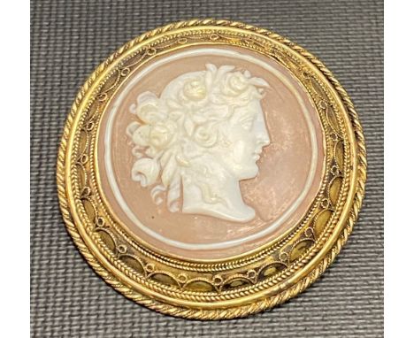 19th Century yellow metal mounted circular cameo brooch carved with a portrait of a woman with floral garland, diameter 4cm.