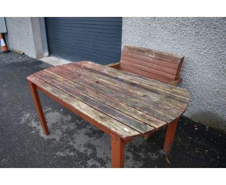 A large stained wood garden table and bench