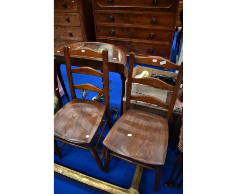 A pair of traditional solid seat ladder back kitchen chairs