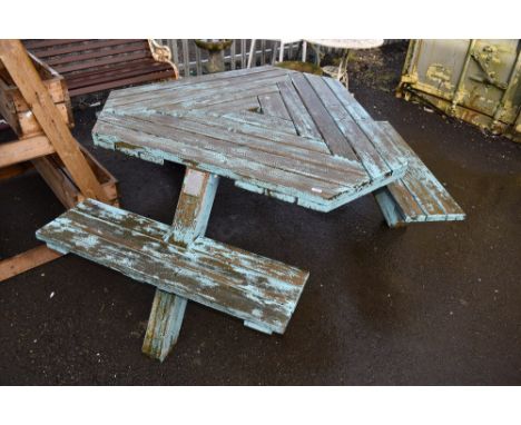 A triform garden table, labelled Tabula, with integral seating
