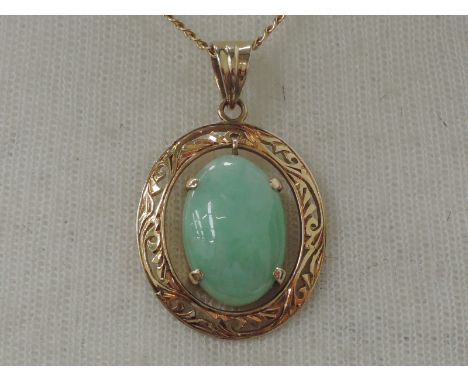 A jade pendant within a pierced yellow metal mount stamped 14K on a 9ct gold chain, with copy of original receipt from Hong K