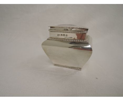 A silver tea caddy of plain casket form having a hinged lid and gadrooned decoration, Birmingham 1911, Charles Westwood & Son