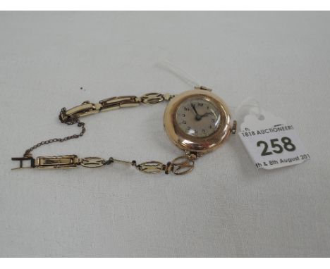 A lady's vintage 9ct gold wrist watch having an Arabic numeral dial with gilt dot decoration on a rolled gold decorative stra