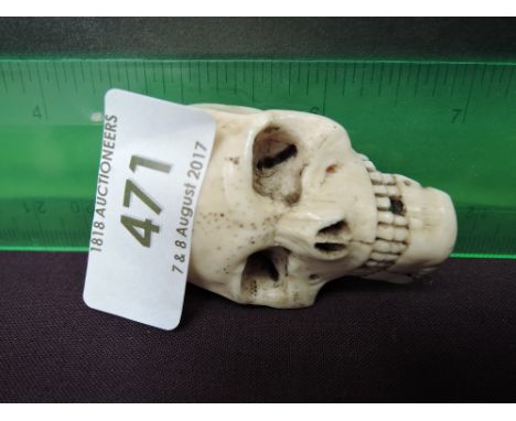 A 19th century ivory half netsuke modelled as a skull
