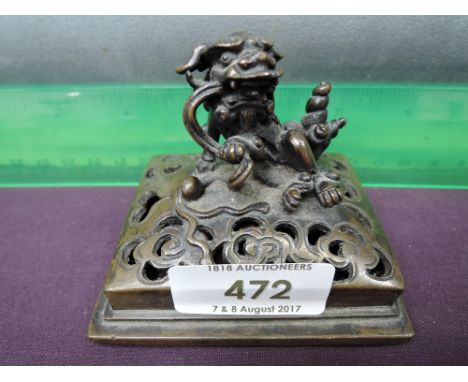 A 19th century Chinese bronze trinket modelled as dog of fo, on pierced scroll stand
