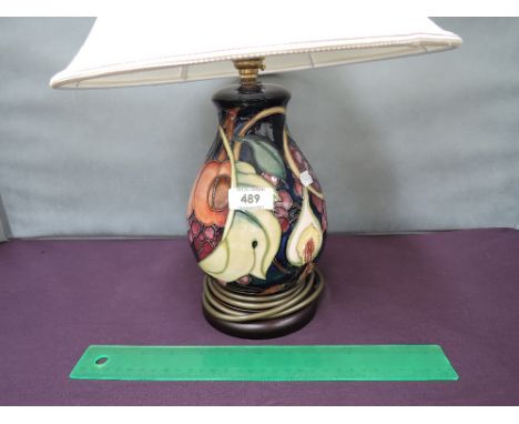 A Moorcroft table lamp in the Queens Choice pattern on blue ground, with shade