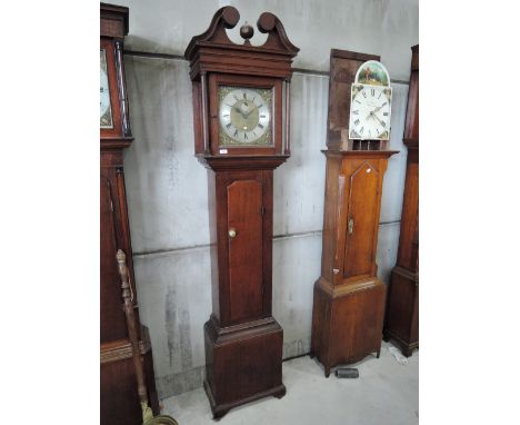 A late 18th century oak longcase clock having swan neck and pillar hood containing square brass and silvered face by William 