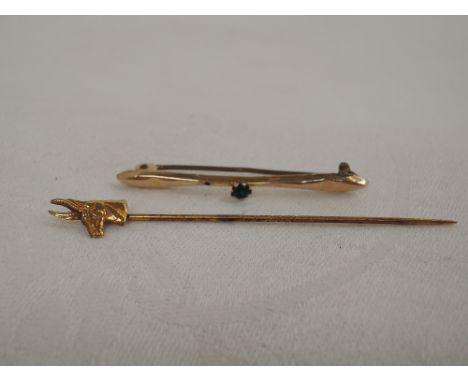 A yellow metal stick pin stamped 9ct having Antelope detail and a yellow metal bar brooch stamped 9ct having green paste ston