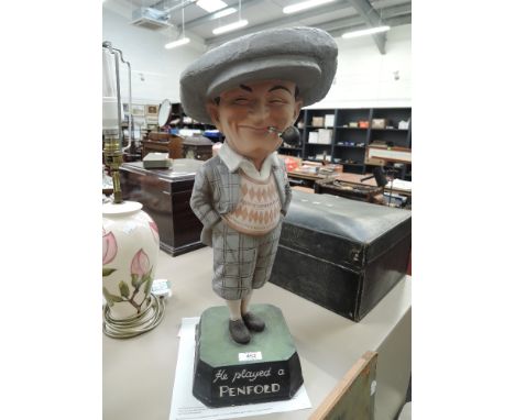 A painted plaster figure modelled as a vintage Penfold Golfer in traditional dress