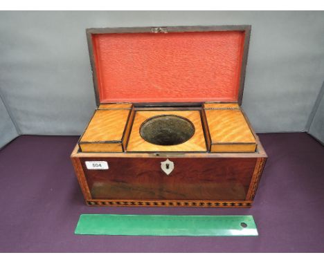 An early 19th century mahogany tea caddy having chequer and line inlay decoration with brass lion mask handles and fitted sat
