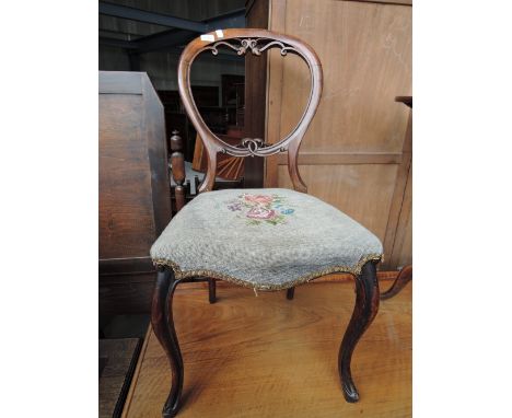 A Victorian mahogany salon chair having scroll balloon back, with floral tapestry seat and cabriole legs