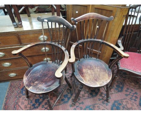 A pair of late 19th/early 20th century stained frame chairs having comb backs with circular solid seats on turned legs