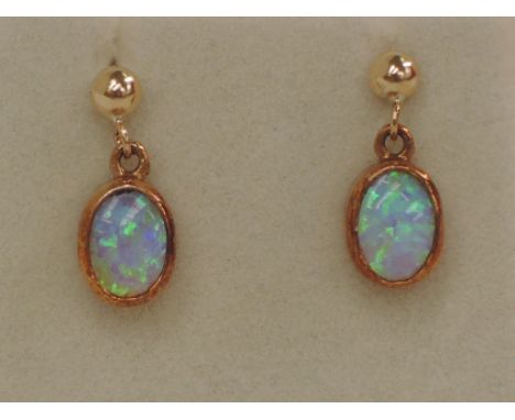 A pair of 9ct gold earrings having oval opal drops