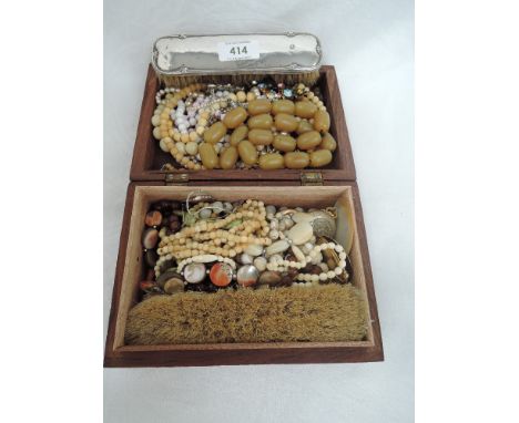 A wooden box containing a selection of vintage costume jewellery including strings of beads and pearls, rolled gold pendant, 