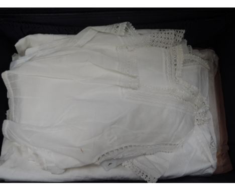 A vintage suitcase containing a selection of Victorian cotton and lawn lady's under garments including lace edged bodice tops