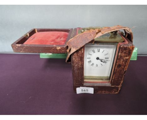 A brass carriage clock of traditional design in fitted leather carry case