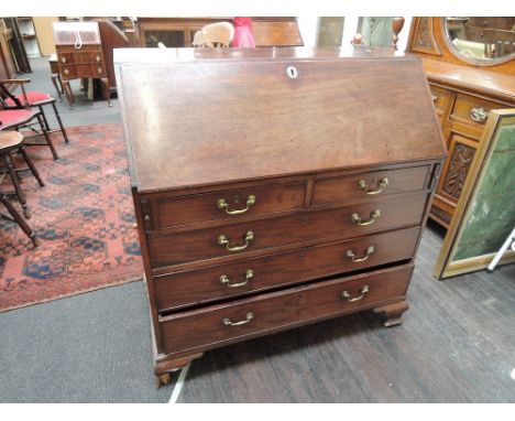 An early 19th century mahogany bureau having fall flap with fitted interior and drawer base on bracket feet