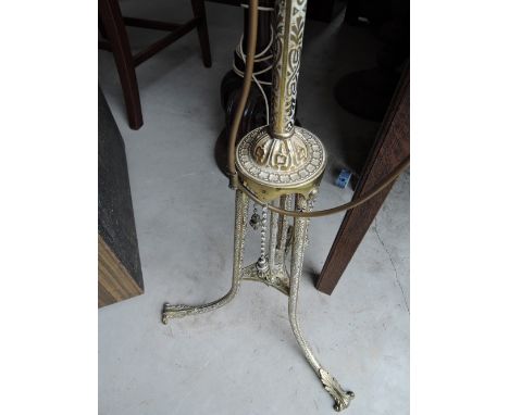 An early 20th century brass standard lamp of Eastern design having trefoil legs