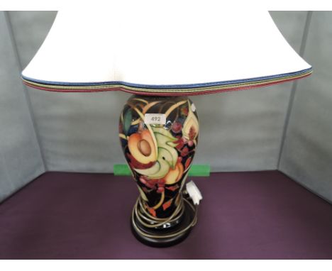 A Moorcroft table lamp in the Queens Choice pattern on blue ground, with shade