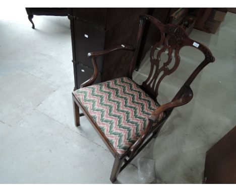 A 19th century mahogany carver armchair in the Chippendale fashion having scroll back and arms with later drop in seat and sq