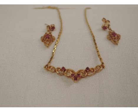 A 9ct gold necklace having a moulded central panel with ruby decoration and matched pair of 9ct gold stud earrings having dia