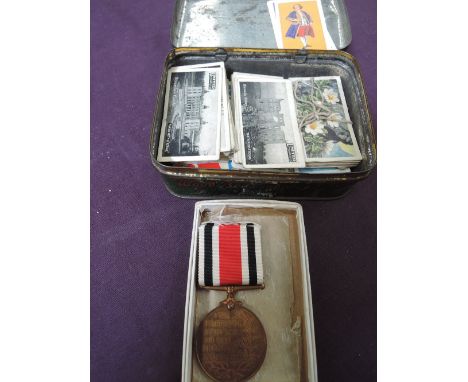 A small collection in a tin of cigarette and trade cards including United Automobile, churches castles and a George VI Specia