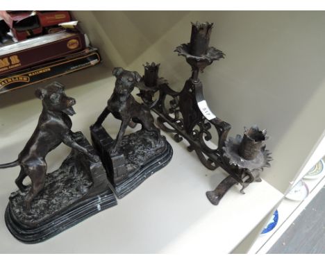A vintage wrought iron candlestick of Bavarian design and a pair of modern cast bookends modelled as gun dogs