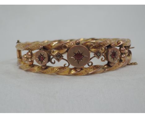 An Edwardian 9ct gold hinged twist hoop bangle having ruby and diamond decoration,  approx 11.6g