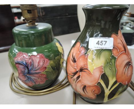 A Moorcroft table lamp of bulbous form having hibiscus pattern on green ground and a similar Moorcroft table lamp