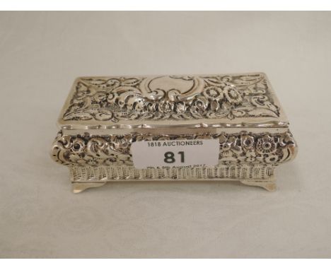 A Victorian silver box having hinged lid, extensive repousse floral decoration, plain cartouche and bracket feet, Birmingham 