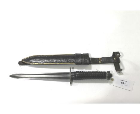 A DAGGER & SCABBARD. A 20thC military style fighting knife/dagger with hollow ground 7.1/8" blade. Steel crossguard with leat