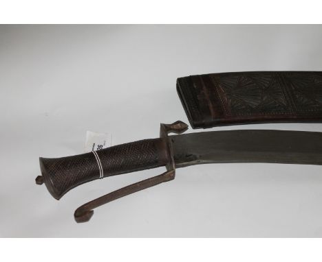 AN EASTERN SWORD. A large yatagan shaped blade eastern sword, with chequered wooden grip and pommel in the Kukri hilt style. 