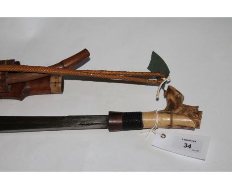 A DYAK MANDAU  A bone mounted Mandau with carved bone pommel and grip, complete with its Anak Mandau knife. Wooden bound scab