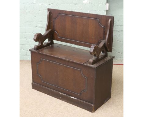 An oak monks bench with carved lion supports.