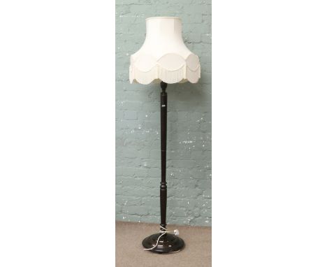 A turned wooden standard lamp and shade.