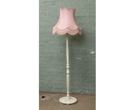 A cream painted fluted column standard lamp with pink shade.