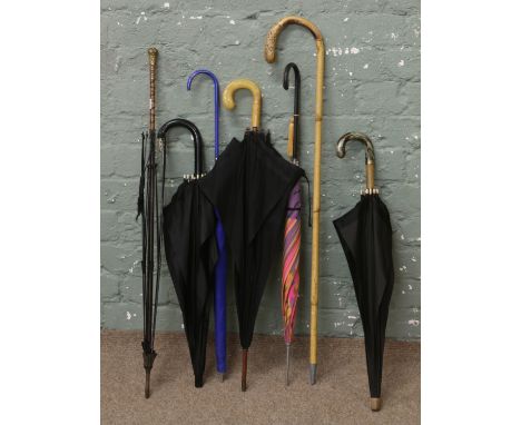 A collection of parasols, walking stick etc to include some with decorative handles.