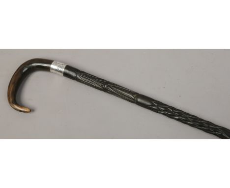 A horn handled carved ebony walking stick with white metal engraved and monogrammed collar.