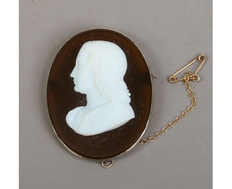 A large ovoid portrait cameo brooch on clear amber coloured ground.