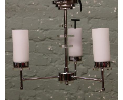A polished three branch designer centre light with milchglas shades and shade removal key.