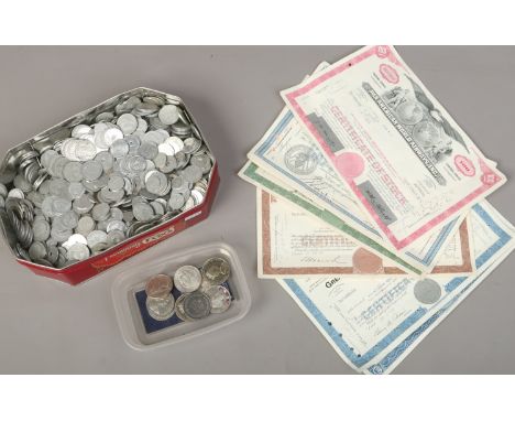 A tin of mixed coins medals and transport tokens, American share certificates etc 