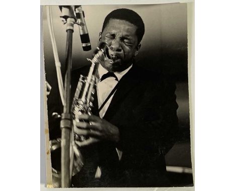 An original photograph depicting John Coltrane onstage in Antibes, France, 1965. Affixed loosely to a board. Stamped to verso