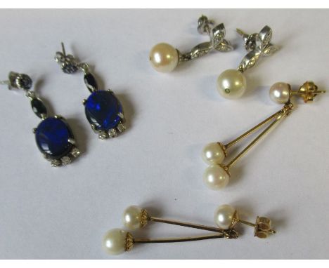 A pair of 14k white gold drop earrings each set sapphire cluster suspending a marquise-cut sapphire and terminating in a dark