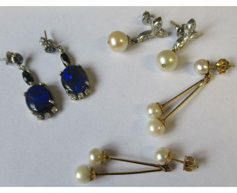 A pair of 14k white gold drop earrings each set sapphire cluster suspending a marquise-cut sapphire and terminating in a dark