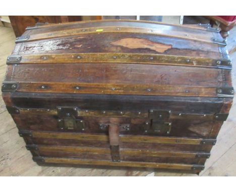 A dome top trunk, in pine and leather, the interior of the lid with cushion lining