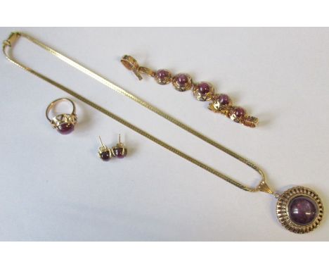 A 14k Italian gold pendant on chain, the circular pendent set with a purple cabachon star sapphire, approx. 17.5mm diameter, 
