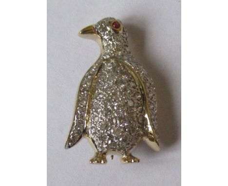 A 14k diamond set brooch, formed as a penguin, with a ruby cabochon eye and pave set numerous round brilliant-cut diamonds, t