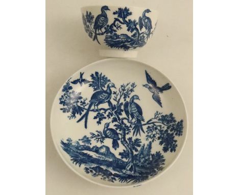 A Worcester tea bowl and saucer, printed in underglaze blue with birds in branches and flight, all in a landscape