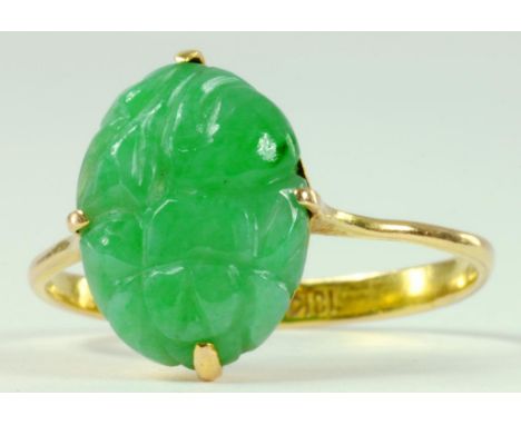 A CARVED JADE RING, IN GOLD, MARKED 18K, 2G